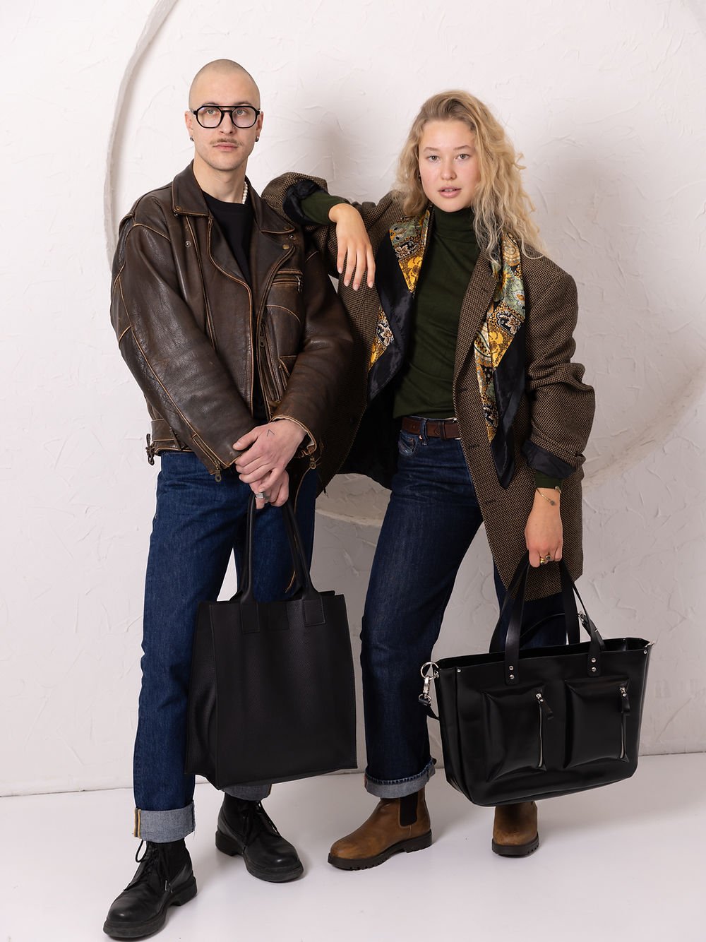 1. Women's black AMBER handbag by TOKS VISOKS, styled with a brown coat and jeans, shown in a lifestyle setting