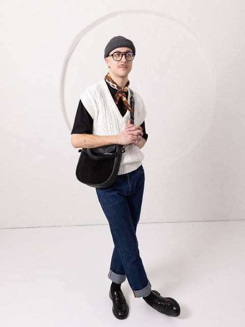 3. Unisex model posing with TOKS VISOKS STELLA black leather handbag, styled with casual outfit in studio