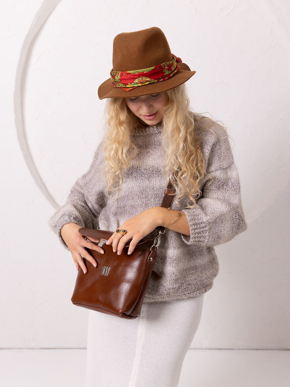 6. Woman adjusting TOKS VISOKS ARLO Purse in ginger, highlighting front design and casual outfit