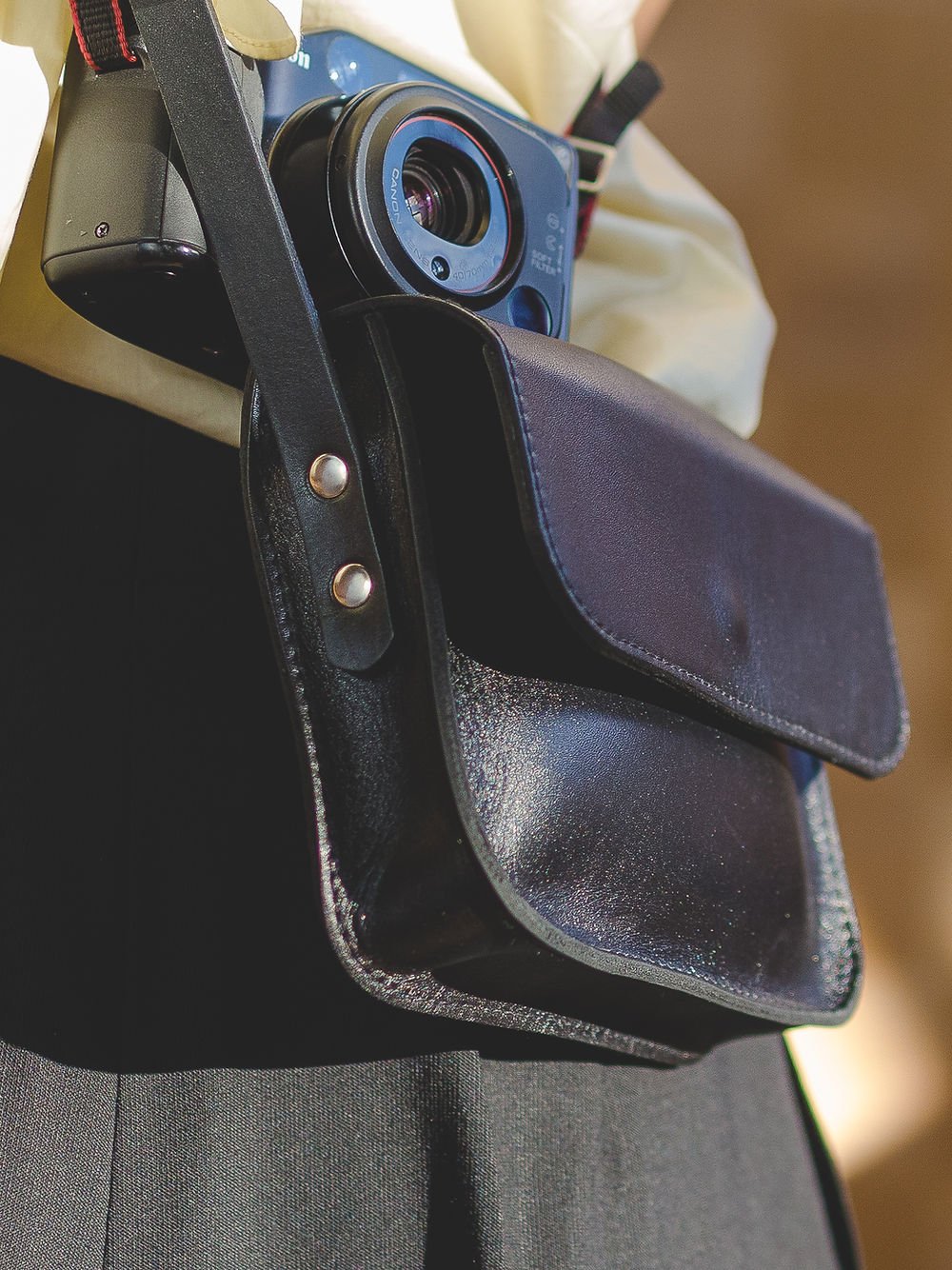 4. Back view of black RUBY Purse by TOKS VISOKS worn by a woman, showcasing adjustable strap