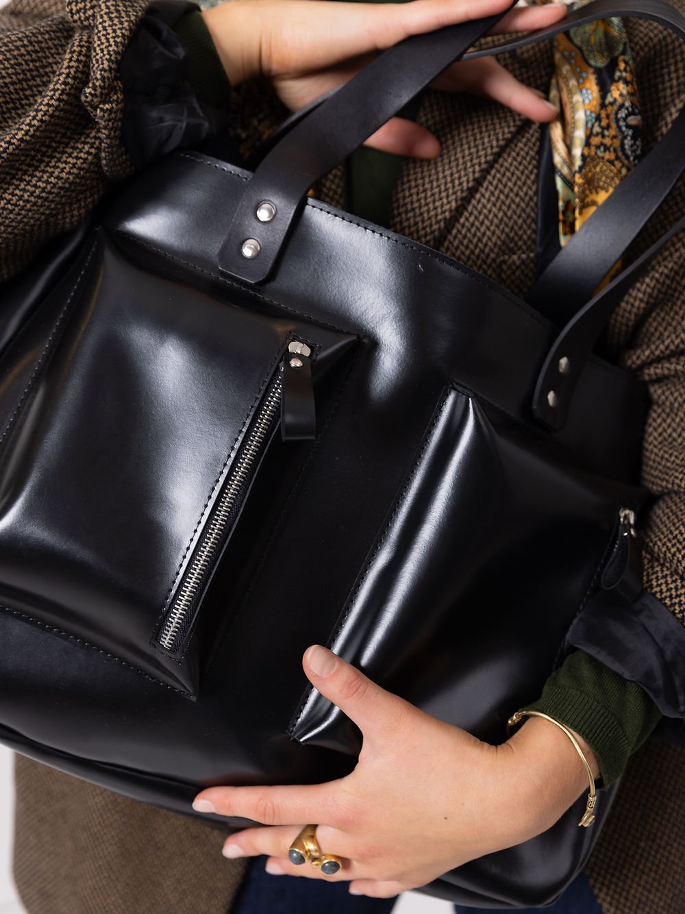 8. Unisex black AMBER handbag by TOKS VISOKS, styled with a male and female model in a studio setting