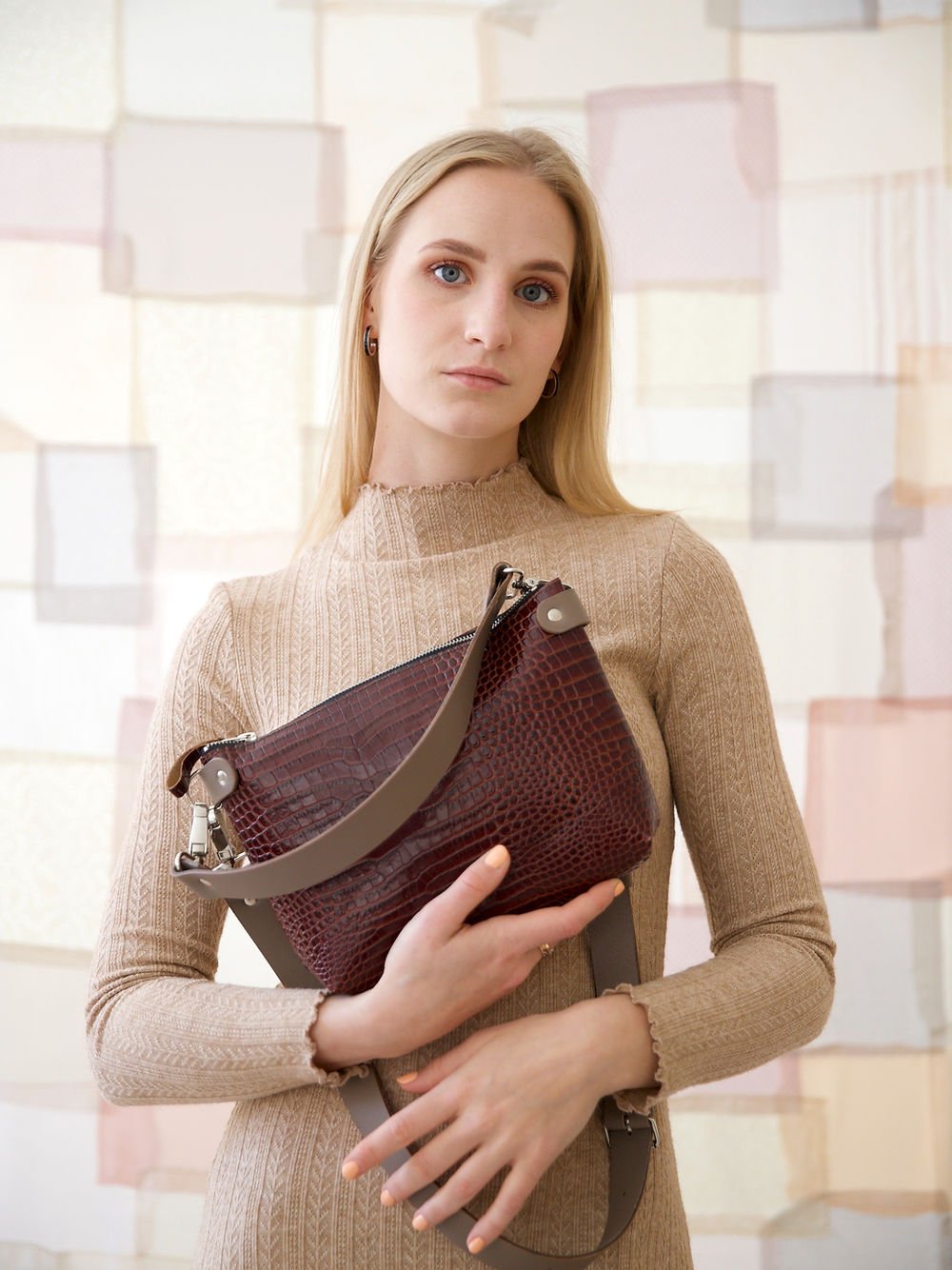 1. Women's TOMMY leather bag with crocodile pattern held by model, showcasing versatility and style