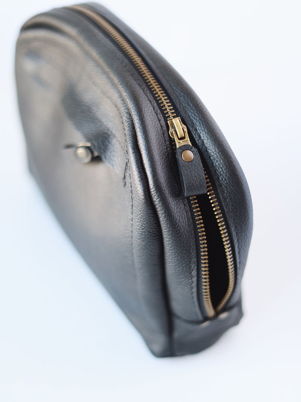5. Detailed view of TOKS VISOKS black leather toiletry bag zipper, highlighting craftsmanship