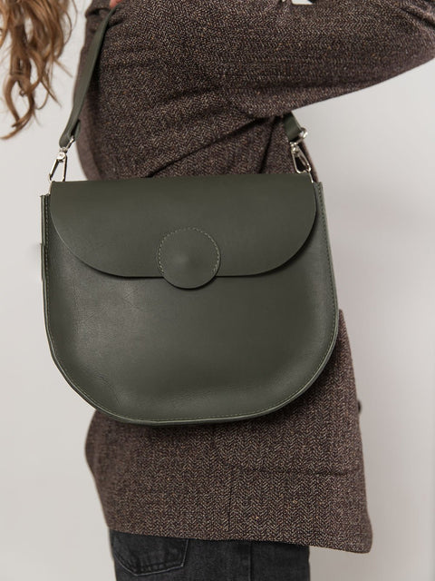 1. Woman wearing TOKS VISOKS FIONA Handbag in faded green with shoulder strap, shown in studio setting