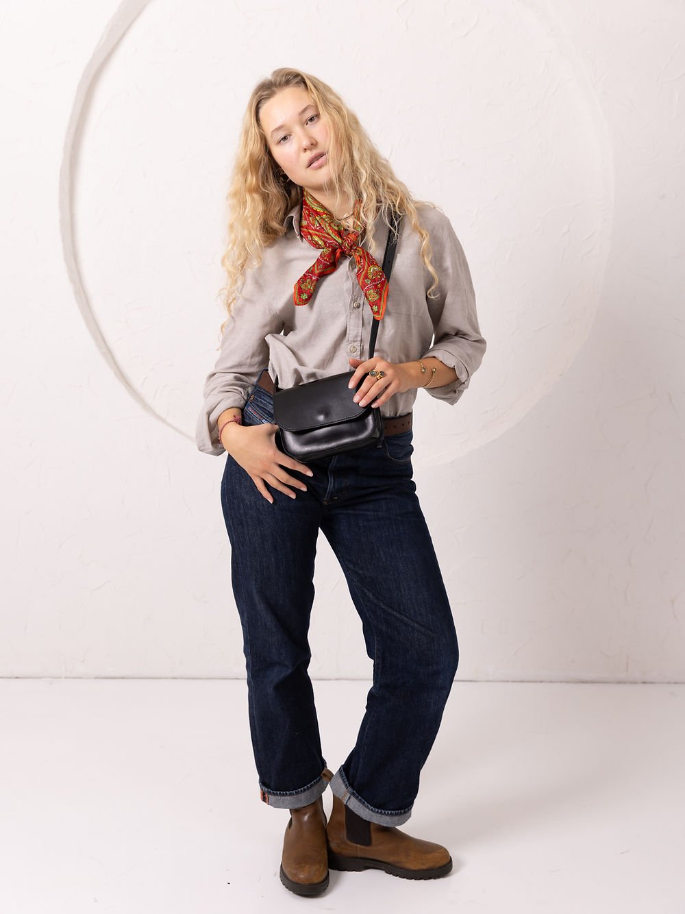 14. Women's black RUBY Purse by TOKS VISOKS worn crossbody, shown in casual studio setting