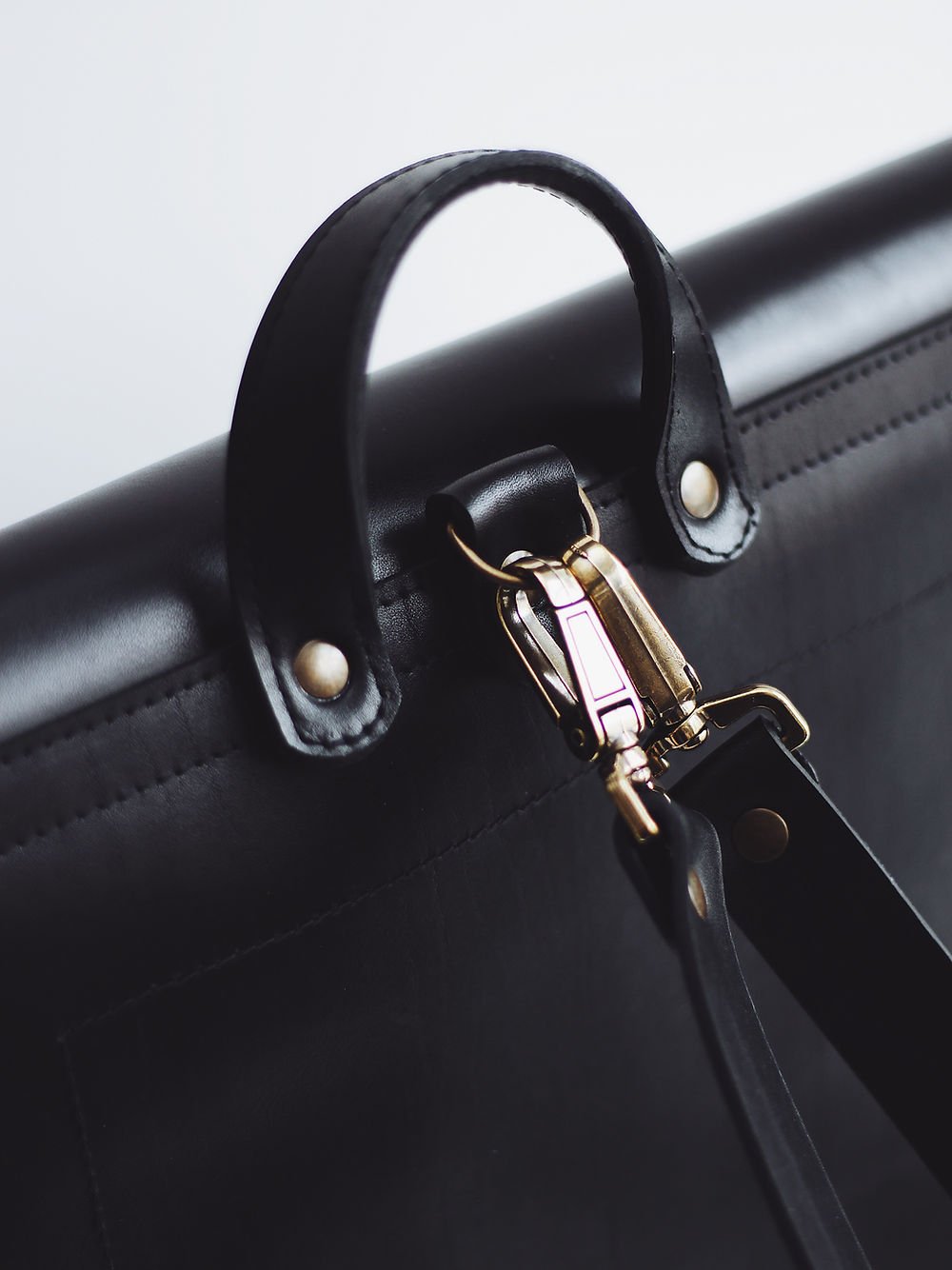 8. Close-up of handle and clasp detail on black leather BENJAMIN Backpack by TOKS VISOKS