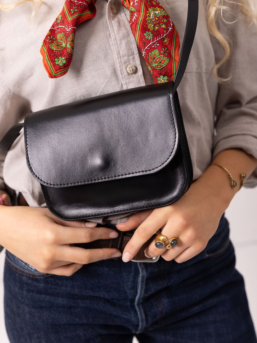 8. Close-up of black RUBY Purse by TOKS VISOKS worn by woman, highlighting magnet buckle