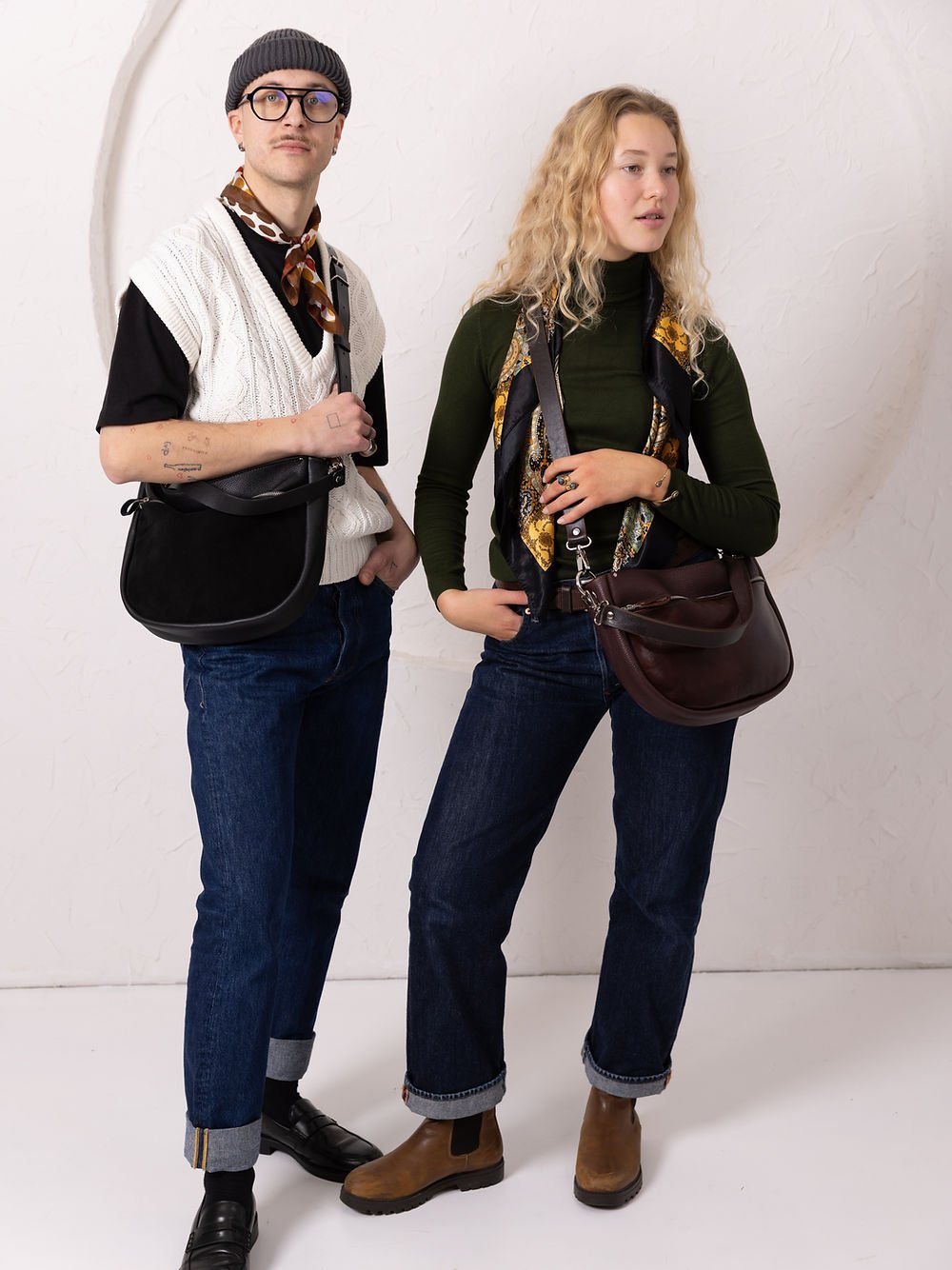 8. Unisex models with TOKS VISOKS STELLA leather handbags in black and brown, styled with casual outfits in studio setting