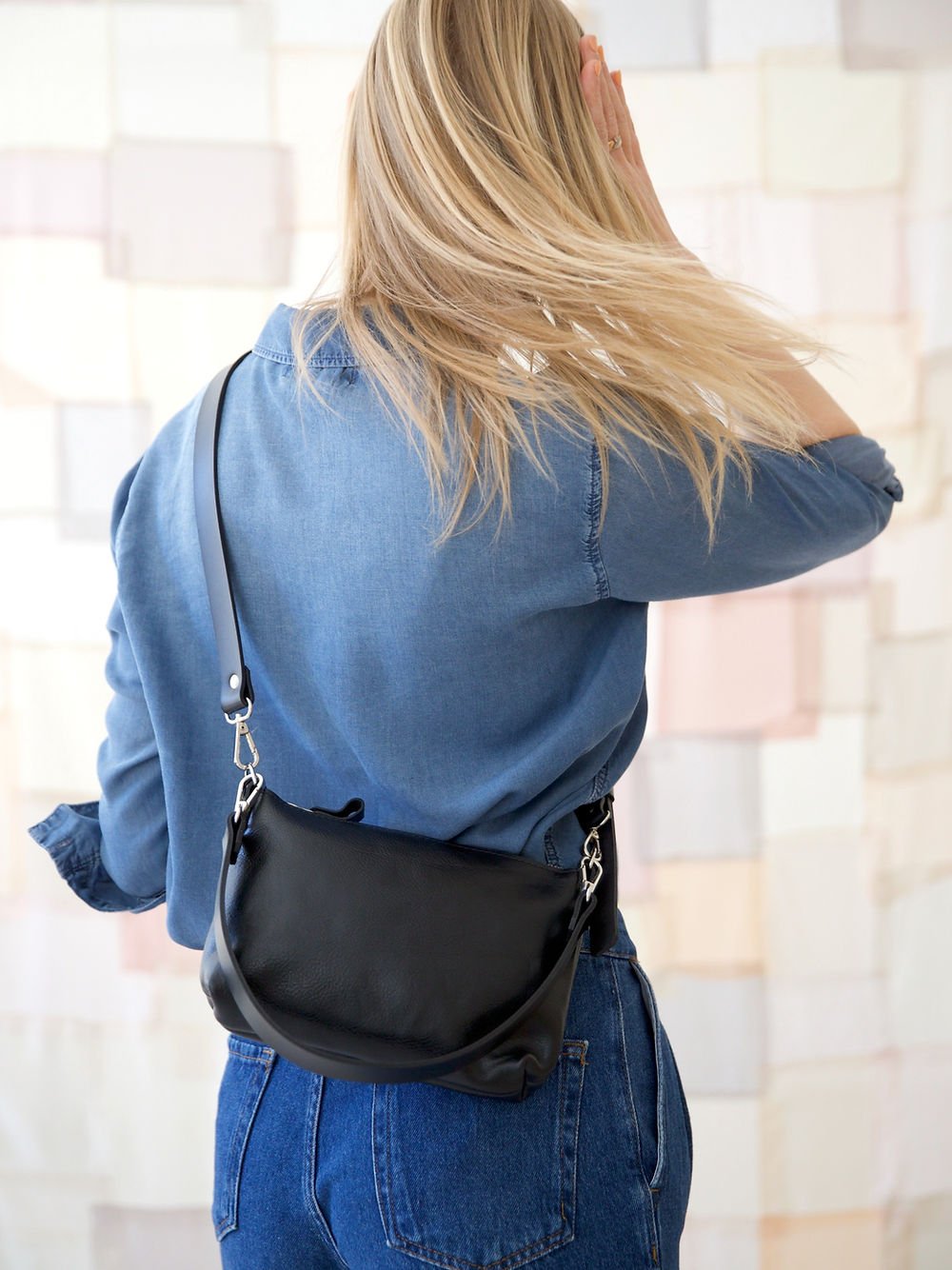15. Women's black TOMMY leather bag by TOKS VISOKS worn crossbody, shown from the back in lifestyle setting