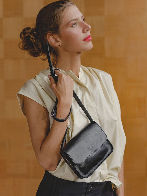 2. Elegant black RUBY Purse by TOKS VISOKS worn by a woman in a chic indoor environment
