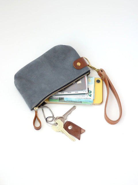 3. TOKS VISOKS grey suede wallet with wrist strap, displaying contents like keys and phone for versatile use