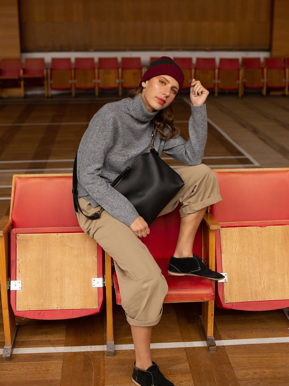 6. Woman sitting with TOKS VISOKS ROBIN large black leather handbag, demonstrating casual elegance and functionality