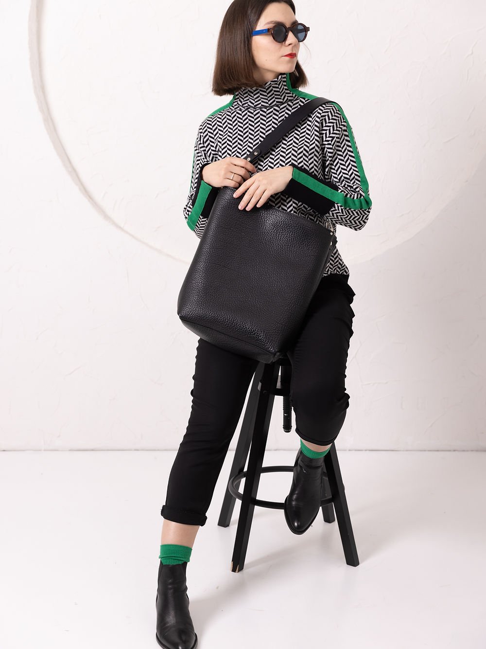 6. Woman seated with ADDISON Leather Tote in black, showing casual elegance and functionality