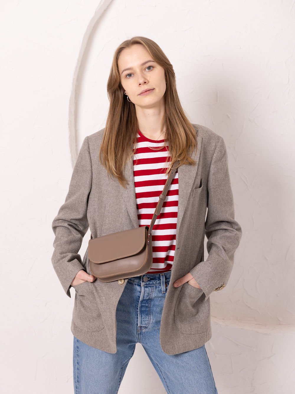 4. Woman wearing TOKS VISOKS RUBY Purse in beige across body, lifestyle setting