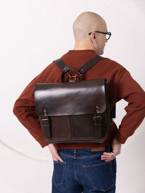 3. Male model wearing TOKS VISOKS BENJAMIN Backpack in dark chocolate leather, shown from the back in studio setting