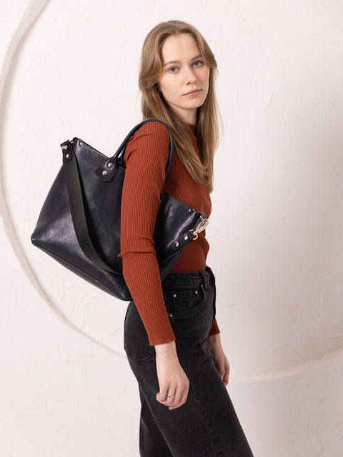 3. Women's MIGLE Leather Handbag in Dark Denim by TOKS VISOKS, shown from side in lifestyle setting