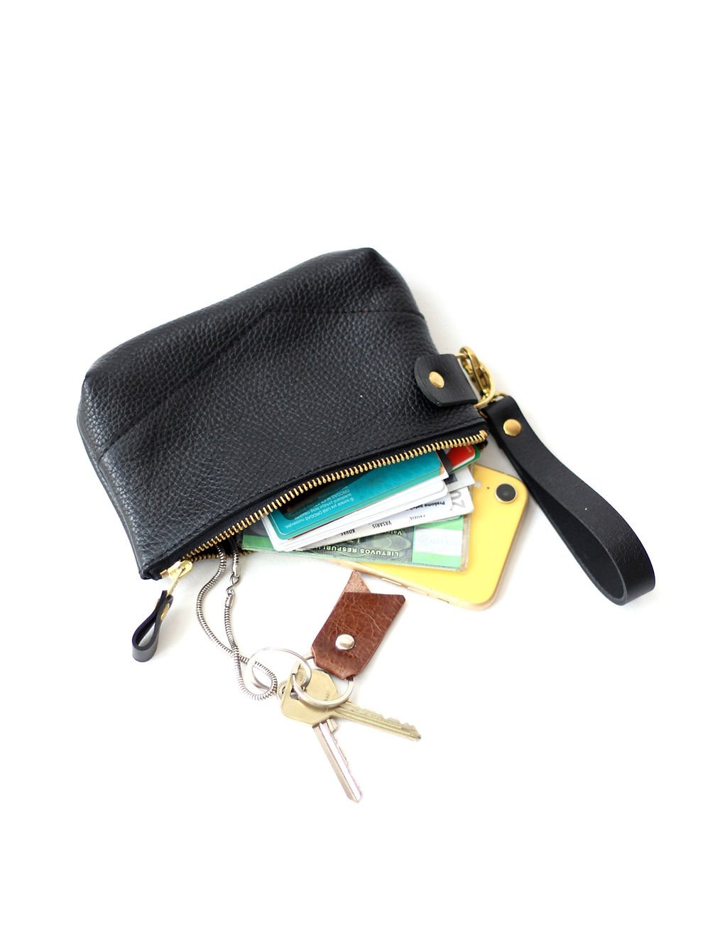 2. TOKS VISOKS POUCH Wallet in black showing contents like cards and keys, with golden zipper open