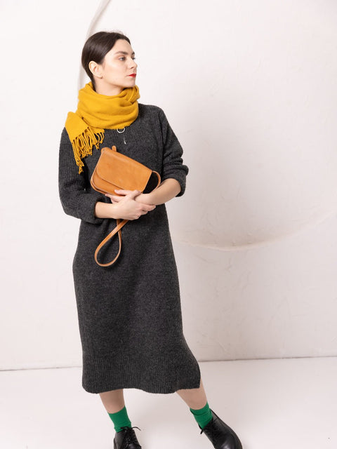 5. Woman posing with TOKS VISOKS RUBY Purse in caramel leather, styled with yellow scarf and dark dress