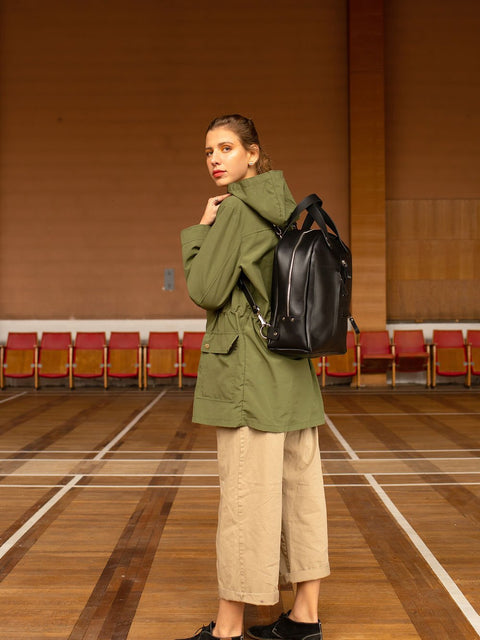 3. Woman wearing TOKS VISOKS GORDON black leather backpack, shown from back in lifestyle setting