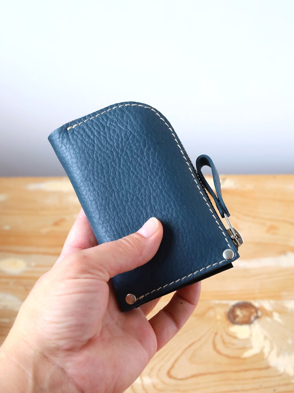 4. Handheld view of blue WEDNESDAY Wallet by TOKS VISOKS showing compact size