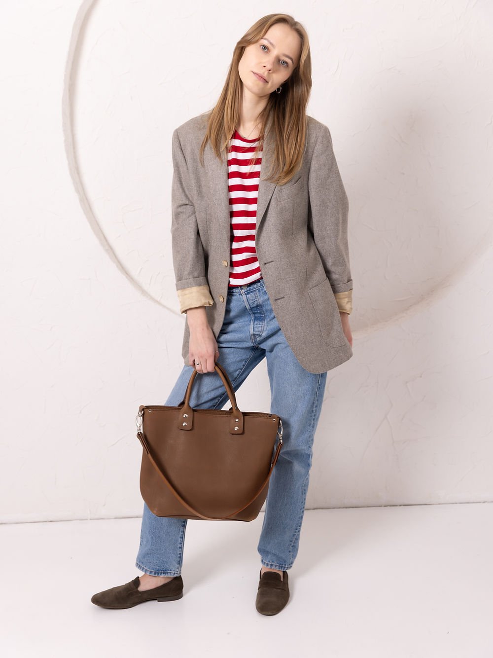 4. Woman posing with MIGLE Leather Handbag in cappuccino by TOKS VISOKS, showing front design