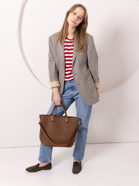 4. Woman posing with MIGLE Leather Handbag in cappuccino by TOKS VISOKS, showing front design