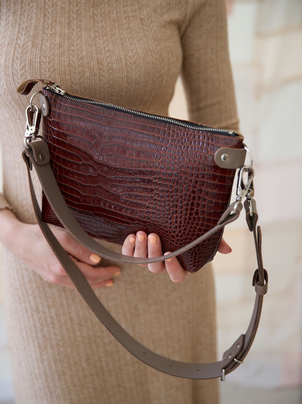 8. Close-up of TOMMY leather bag with crocodile pattern, showing zipper closure and strap details
