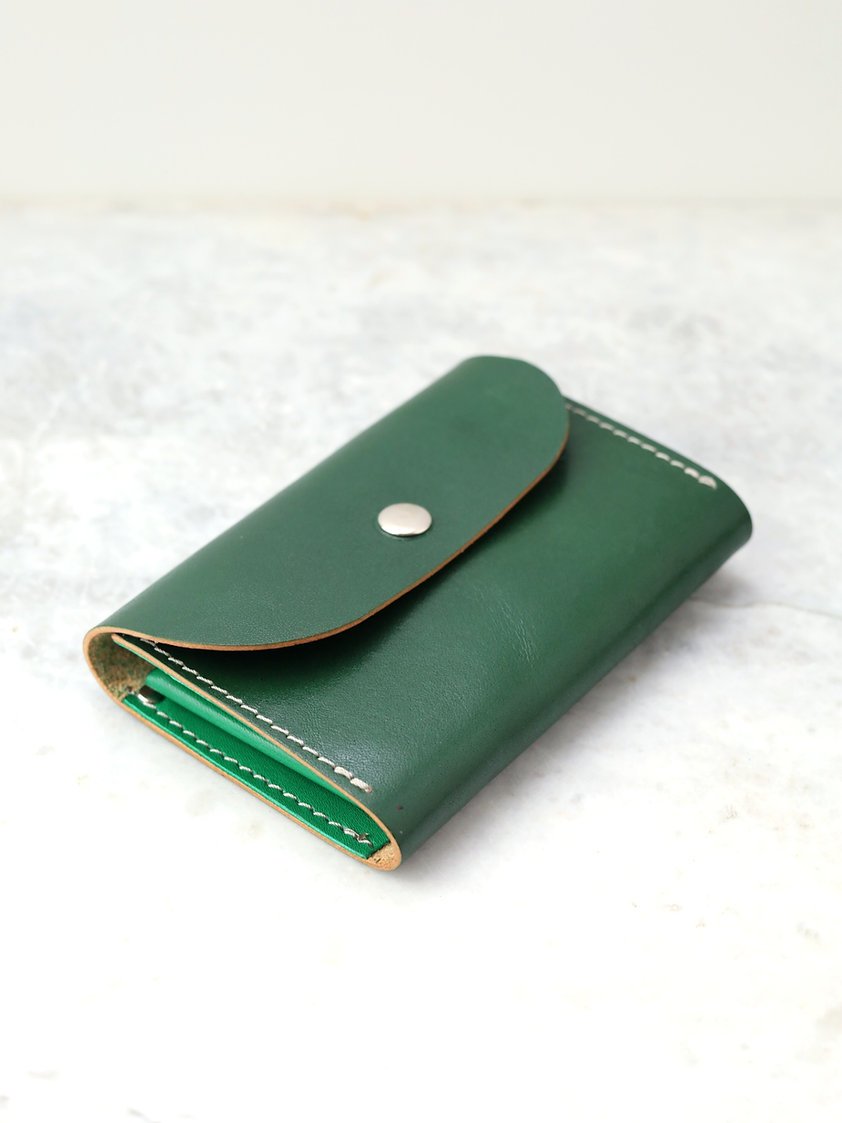 6. Flat lay of the FRIDAY Wallet in green recycled leather, highlighting its sleek and durable design