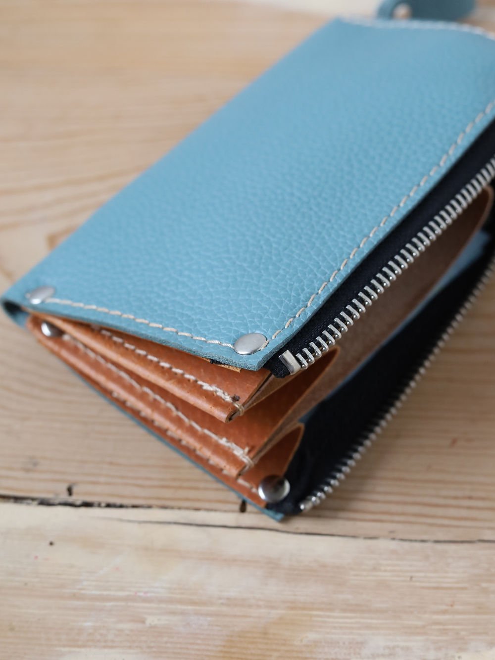 7. Side view of TOKS VISOKS WEDNESDAY Wallet in turquoise, highlighting stitching and zipper design