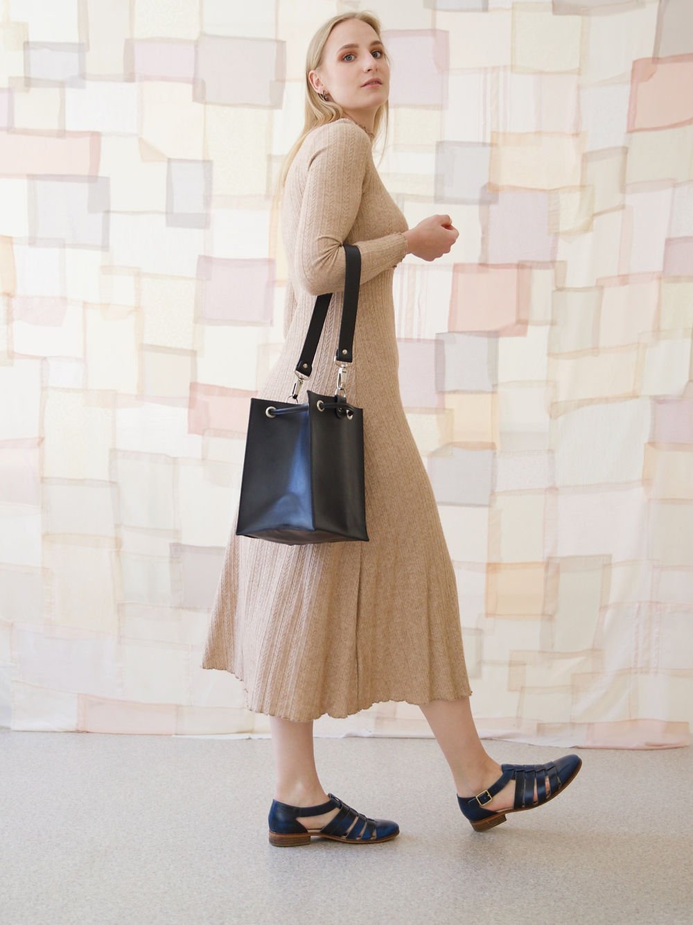 3. Woman walking with black TOKS VISOKS PIPER Purse, showing full outfit and purse in lifestyle setting