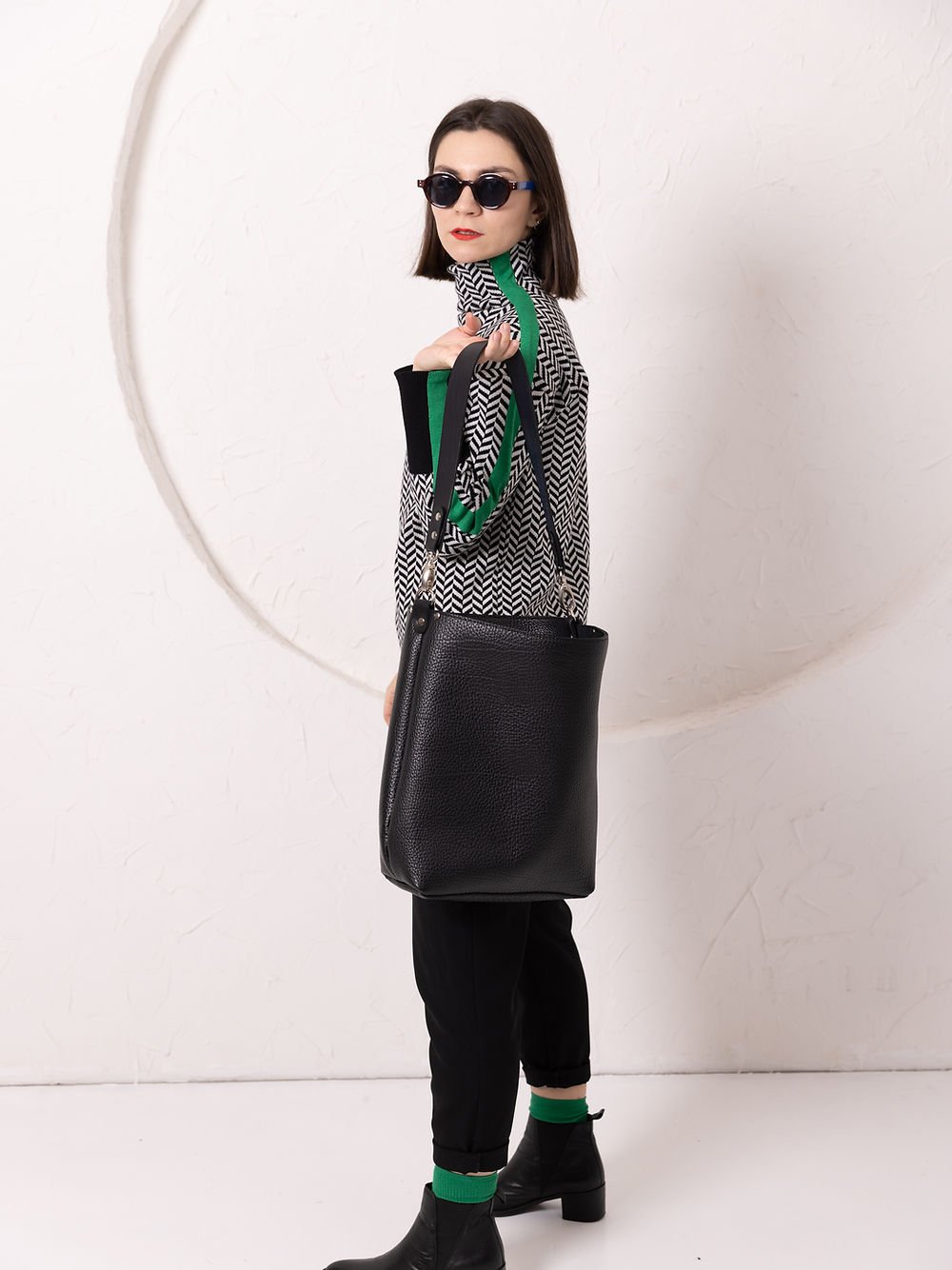 3. Side view of woman with ADDISON Leather Tote in black, highlighting strap length and leather texture