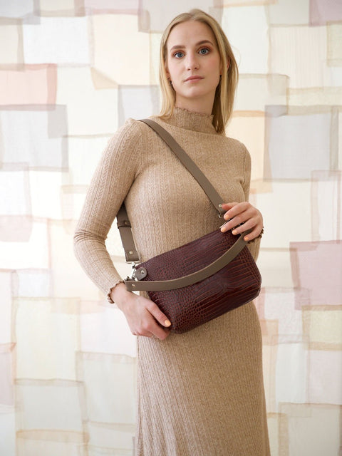 2. Women's TOMMY leather bag with crocodile pattern worn crossbody by model, highlighting adjustable strap