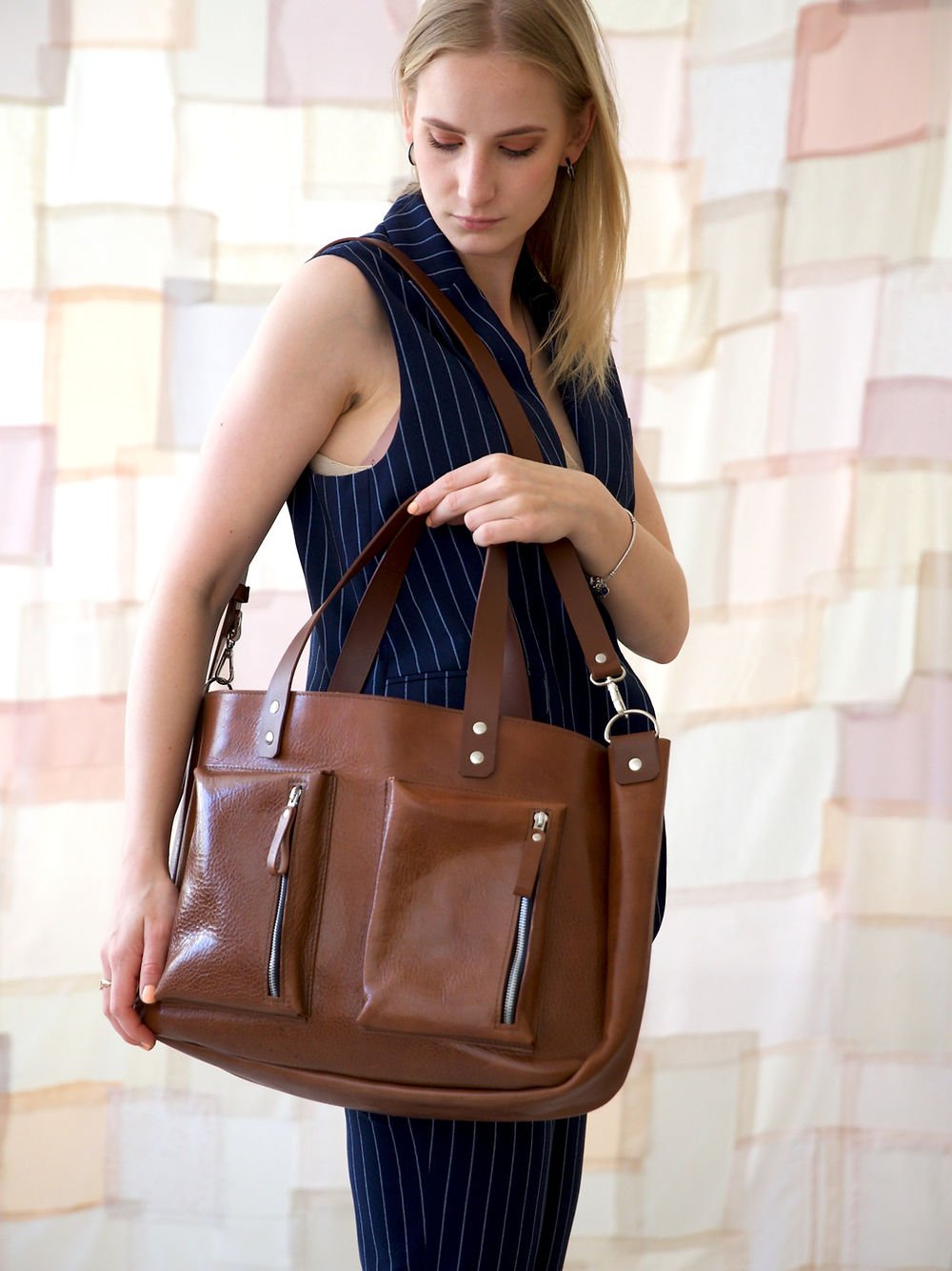 7. Woman holding TOKS VISOKS AMBER handbag, showcasing elegant and practical design