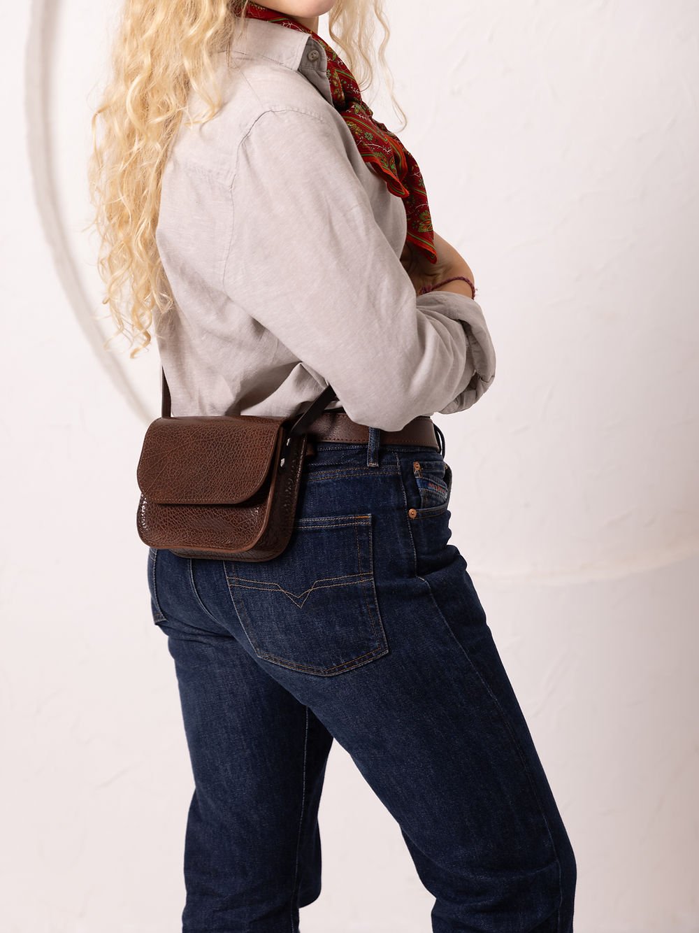 3. Side view of woman wearing brown marble RUBY Purse by TOKS VISOKS, showing adjustable strap