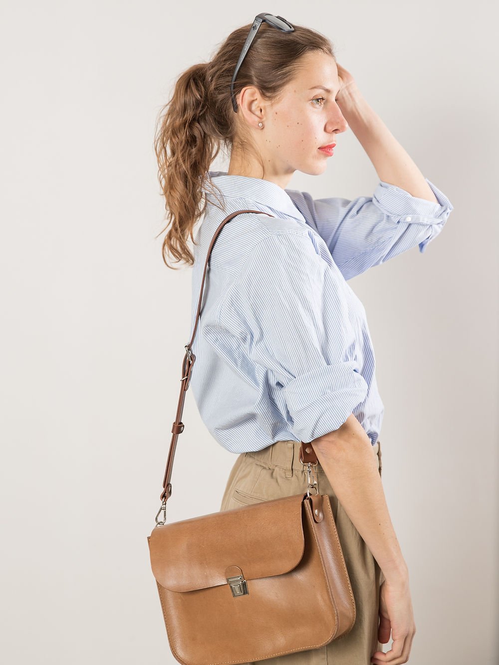 3. Side view of woman with TOKS VISOKS ASTORIA handbag in camel brown, highlighting versatile wear