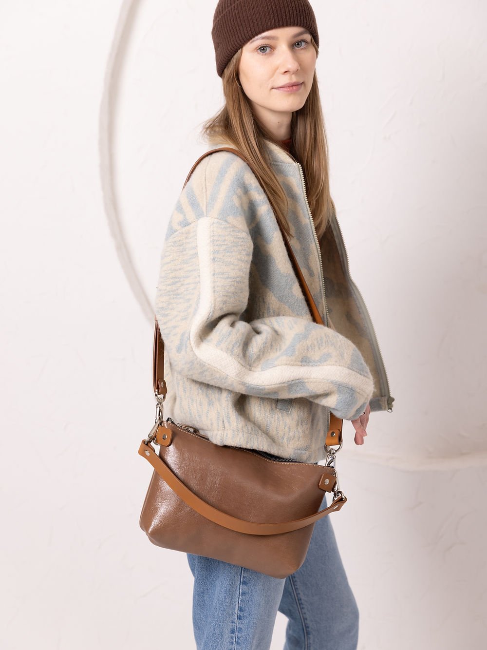 5. Woman showcasing TOKS VISOKS TOMMY leather bag in cappuccino, styled with casual outfit