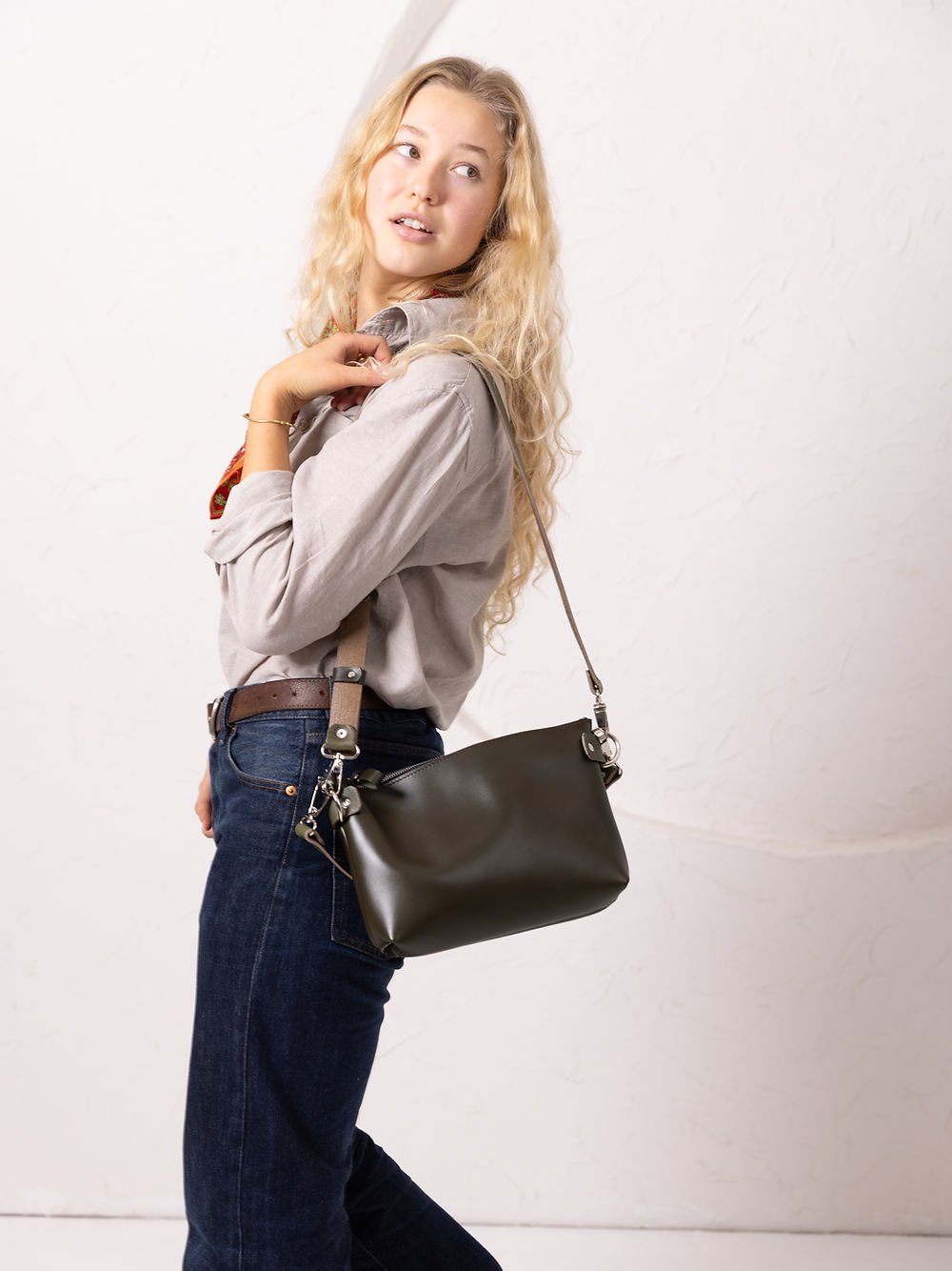 1. Women's TOMMY leather bag in dirty green worn crossbody, styled with casual outfit in lifestyle setting