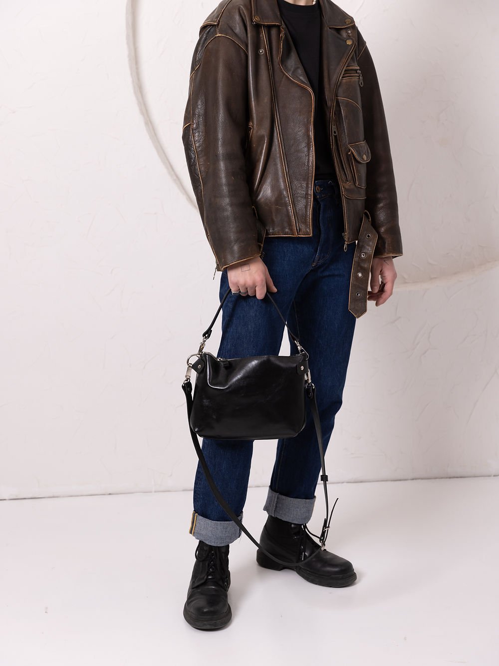 6. Unisex black TOMMY leather bag by TOKS VISOKS styled with leather jacket in studio setting
