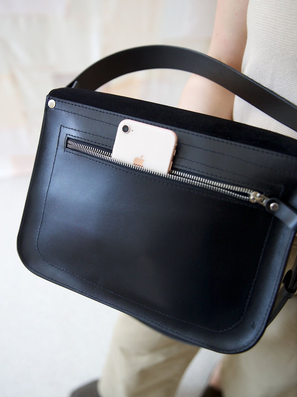 12. Close-up of TOKS VISOKS ASTORIA black suede handbag with phone in back pocket