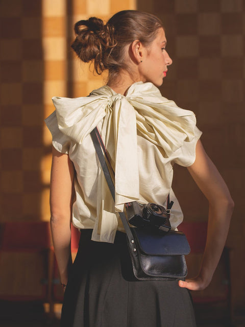 3. Close-up of black RUBY Purse by TOKS VISOKS with camera, highlighting leather craftsmanship