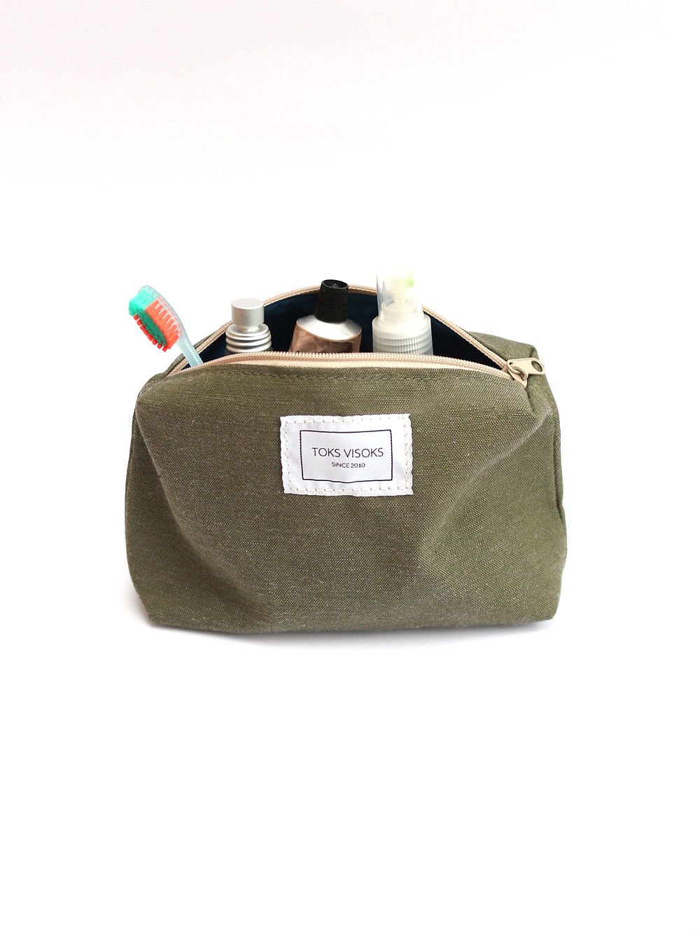 4. Front view of TOKS VISOKS LORNA Makeup Bag in army green, filled with toiletries