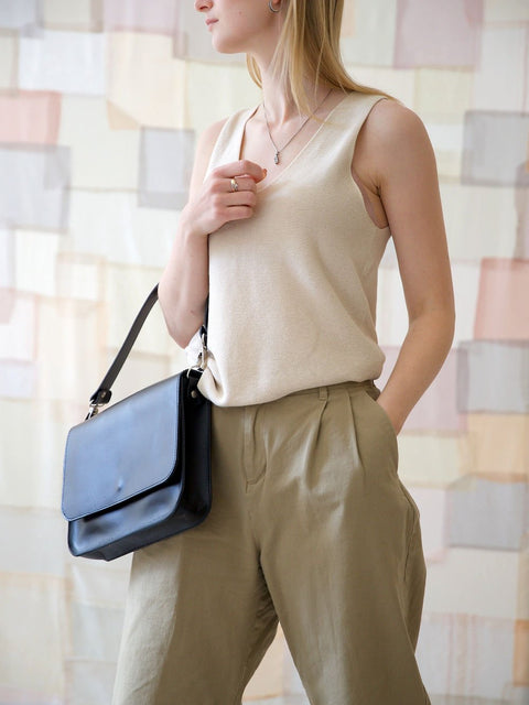 3. Close-up of woman with TOKS VISOKS ASTORIA black handbag, showcasing versatile design