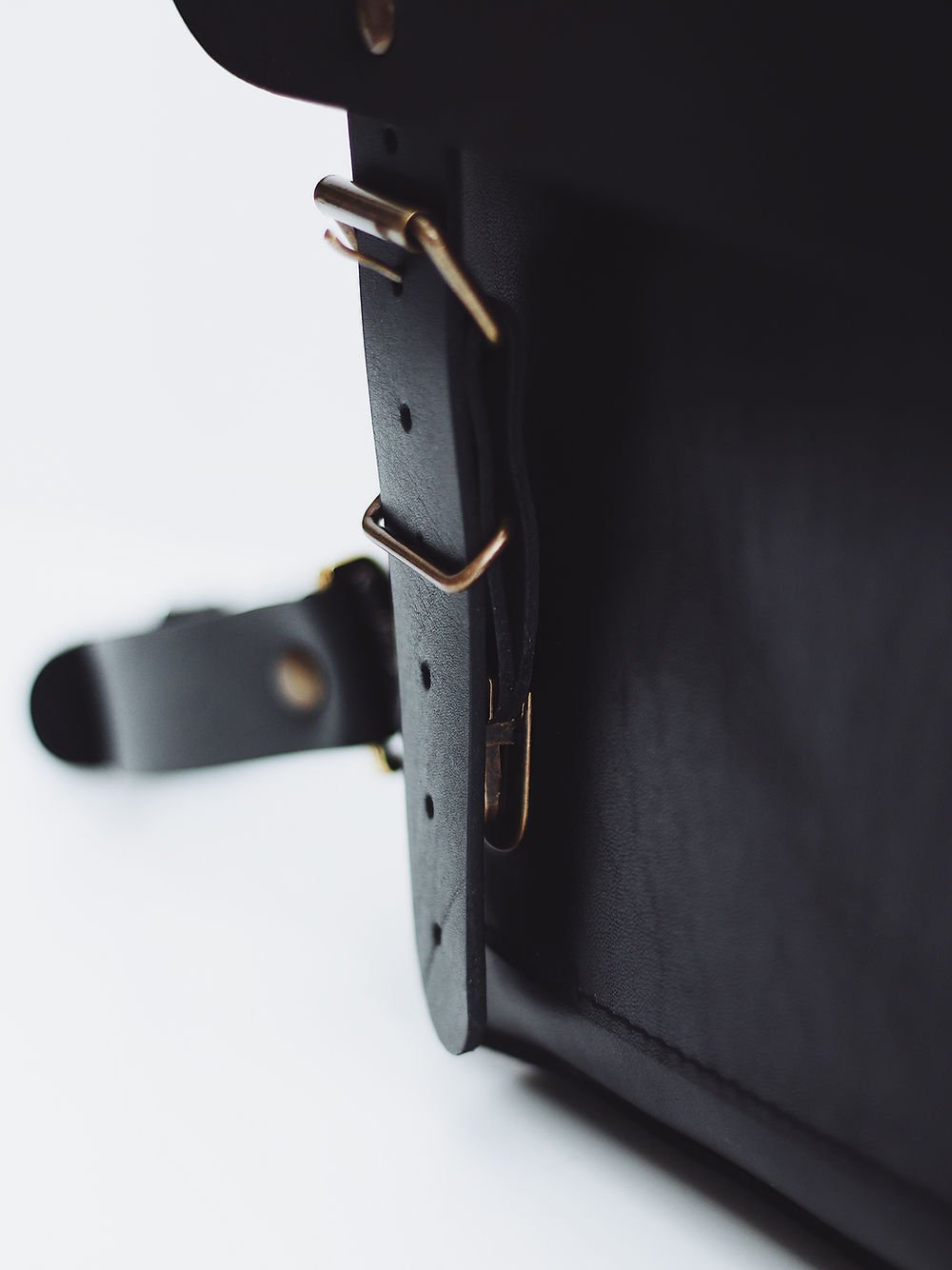 6. Close-up of black leather strap with brass buckle on BENJAMIN Backpack by TOKS VISOKS