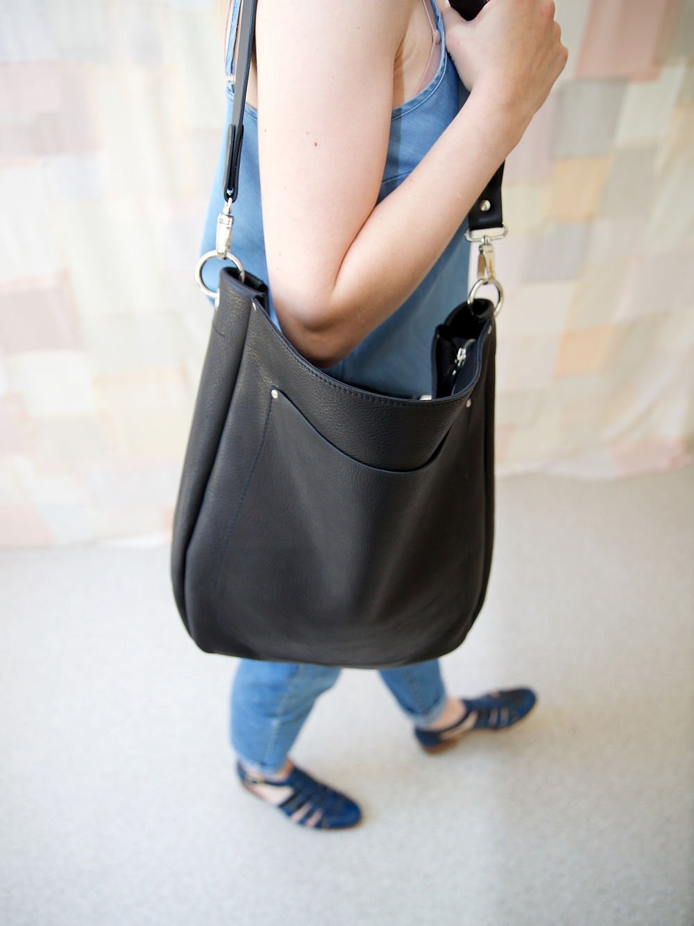 8. Woman walking with LULU black handbag, demonstrating versatile and stylish everyday use