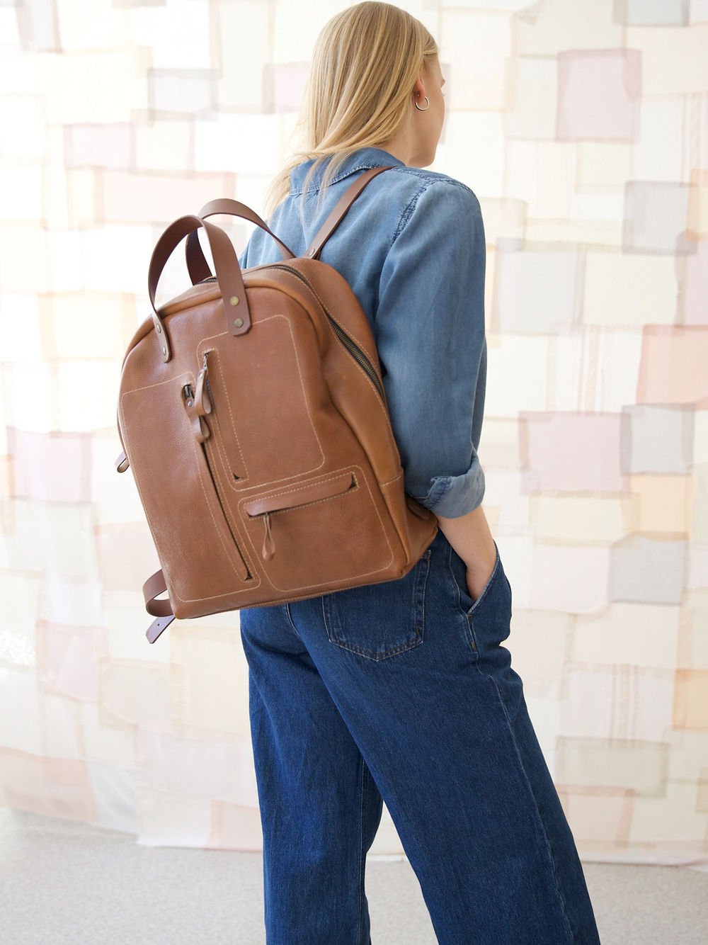 2. Side view of woman wearing TOKS VISOKS GORDON Backpack in Capuccino, lifestyle setting