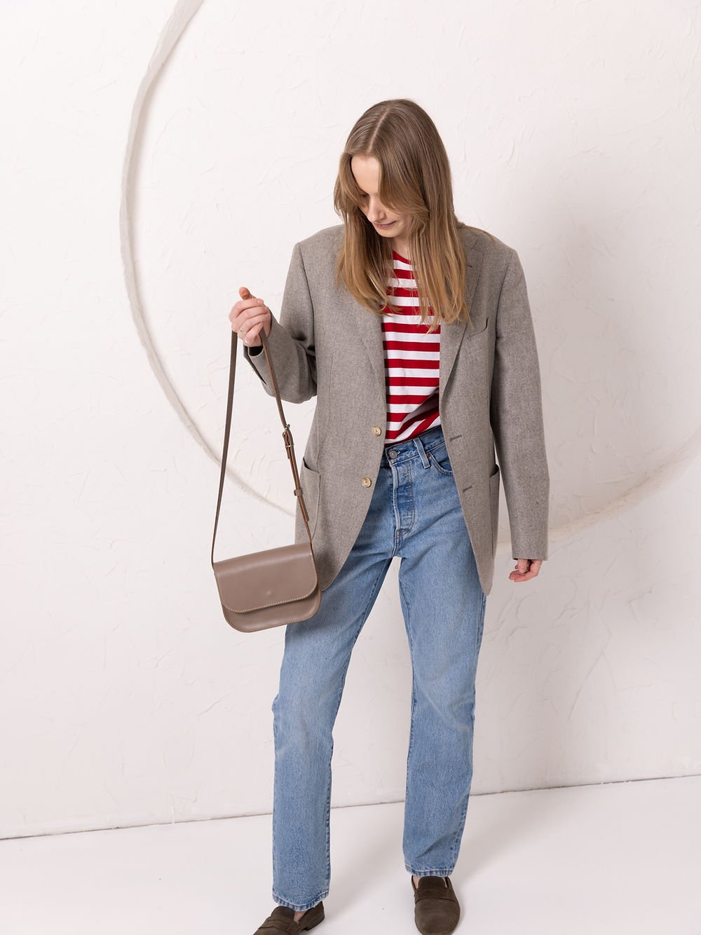2. Woman wearing TOKS VISOKS RUBY Purse in beige, styled with blazer and jeans, lifestyle setting