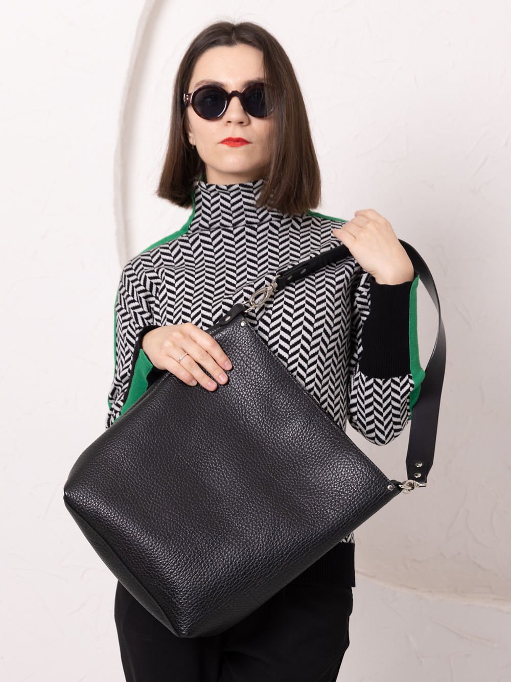 1. Woman holding ADDISON Leather Tote in black by TOKS VISOKS, showcasing classic design and single strap