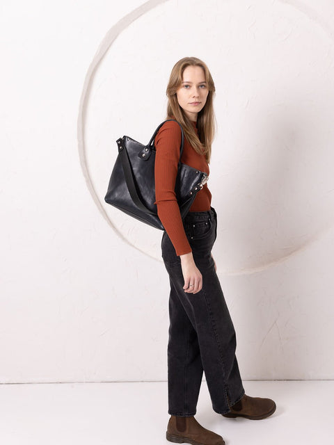 4. Women's MIGLE Leather Handbag in Dark Denim by TOKS VISOKS, worn crossbody in lifestyle setting