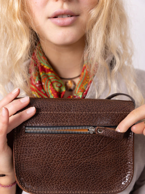 5. Woman seated with brown marble RUBY Purse by TOKS VISOKS, showing compact design