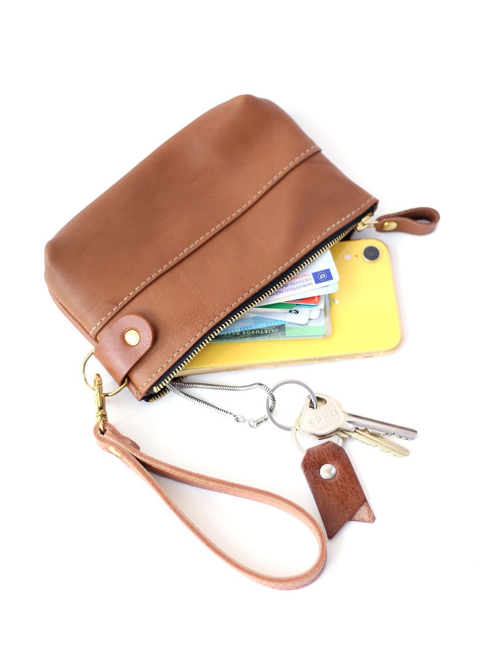 1. TOKS VISOKS POUCH Wallet in camel brown leather with wrist strap, showing contents like cards and keys